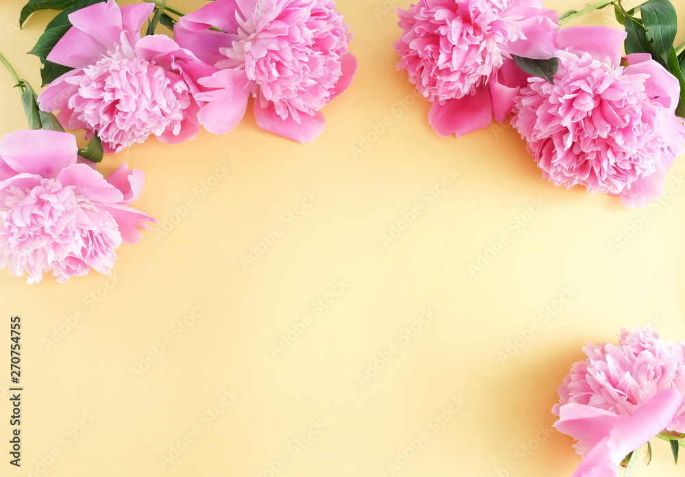 Bouquets of pink flowers peonies frame on pale yellow background. top view. copy space Bouquets of pink flowers peonies frame on pale yellow background. top view. copy space
