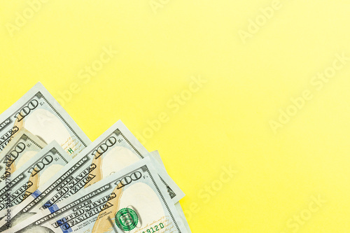 One hundred dollar bills cash lying on yellow background . Financial and business concept. Flat lay, mockup, overhead, minimalism