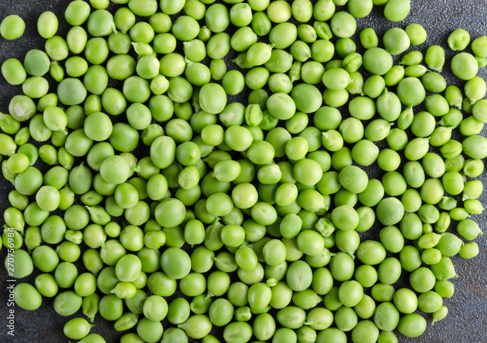 Fresh shelling peeas as a background on the grey surface Fresh shelling peeas as a background on the grey surface