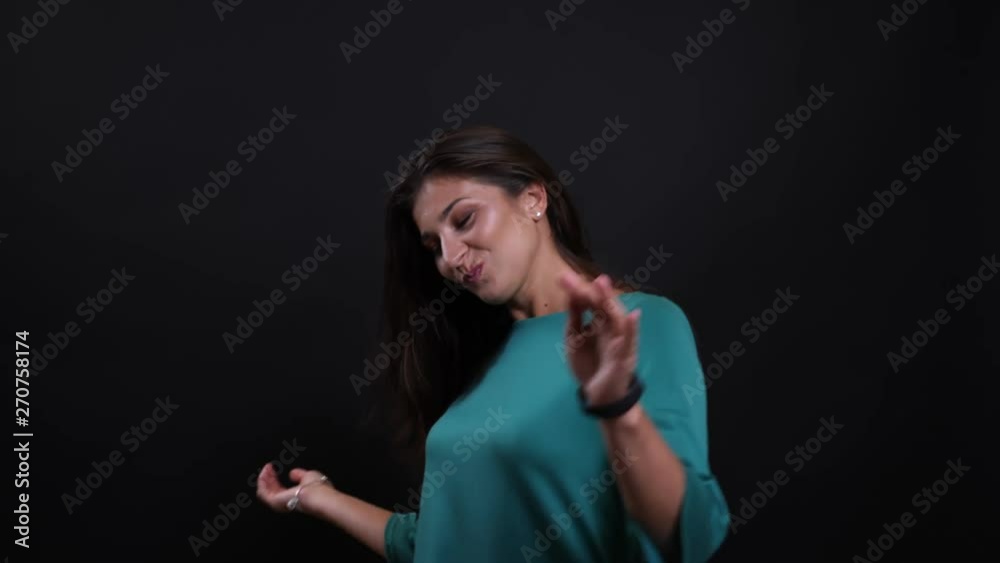 Closeup portrait of young pretty brunette female dancing happily looking at camera with background isolated on black Closeup portrait of young pretty brunette female dancing happily looking at camera with background isolated on black