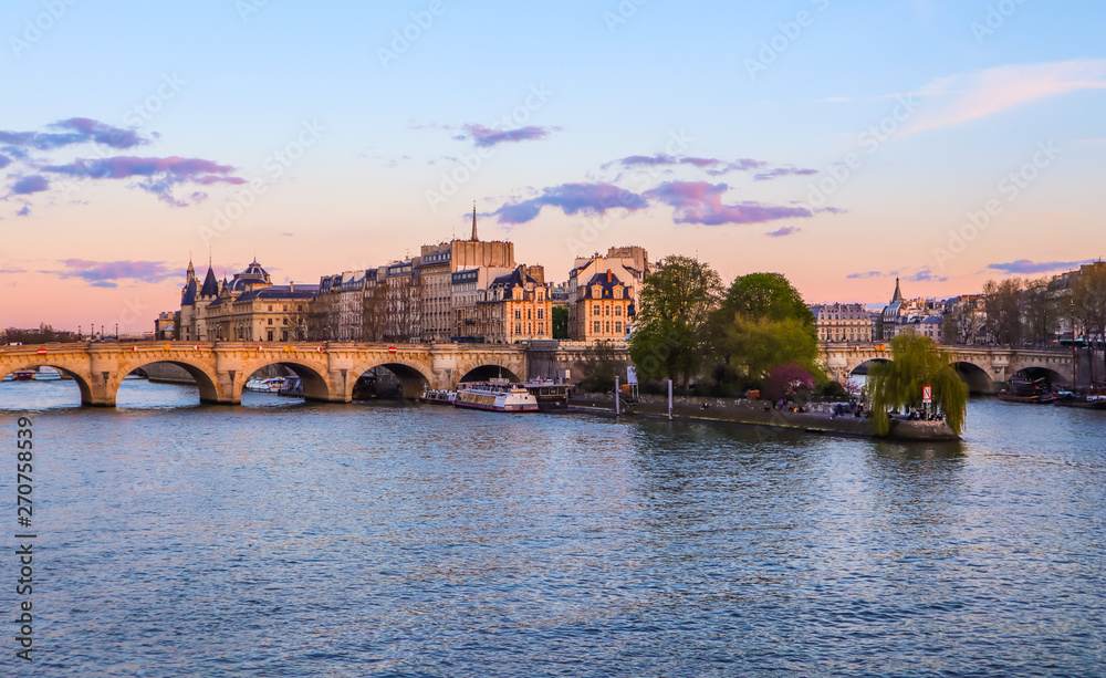 Obraz premium The oldest bridge ( Pont Neuf ) across Seine River and historic buildings of Paris France at sunset. April 2019
