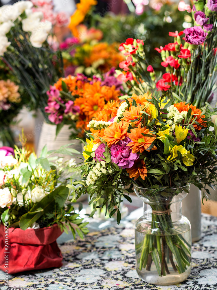 multicolor bouquets of flowers in different containers
