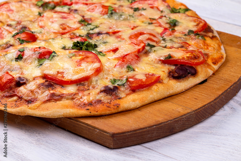 Homemade Italian pizza on wooden tray and white wooden background Homemade Italian pizza on wooden tray and white wooden background