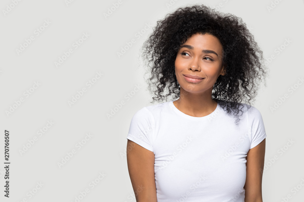 Dreamy african girl pose aside over grey blank background