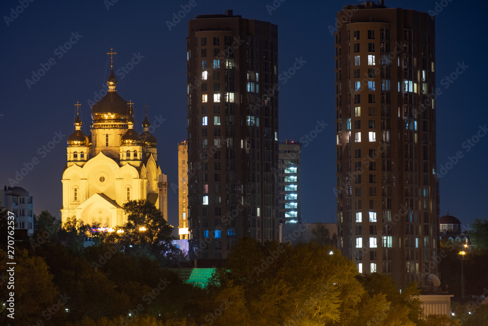 Naklejka premium Night View of the city of Khabarovsk from the Amur river. Blue night sky. The night city is brightly lit with lanterns.