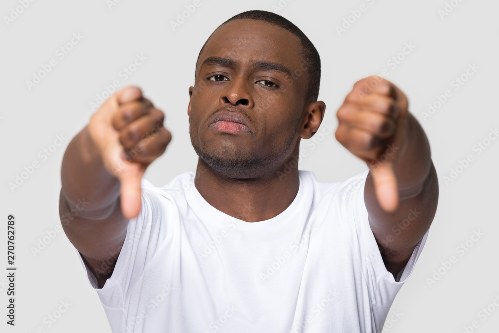 Serious african man showing thumbs down gesture of disapproval Serious african man showing thumbs down gesture of disapproval