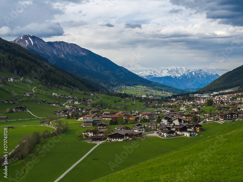 Idyllic spring mountain rural landscape. View over Stubaital or Stubai Valley near Innsbruck, Austria with village Neder and Neustift im Stubaital, green meadow, snow covered alpen mountain peaks