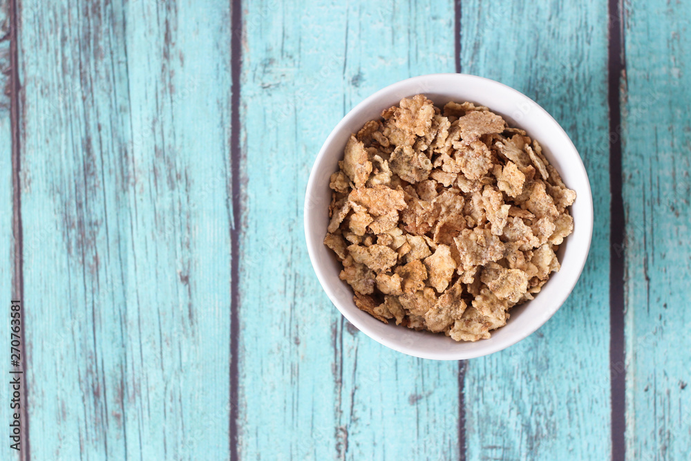 top view of cereals in a white bowl on blue background