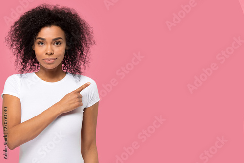 Serious confident african woman looking at camera pointing finger aside photo