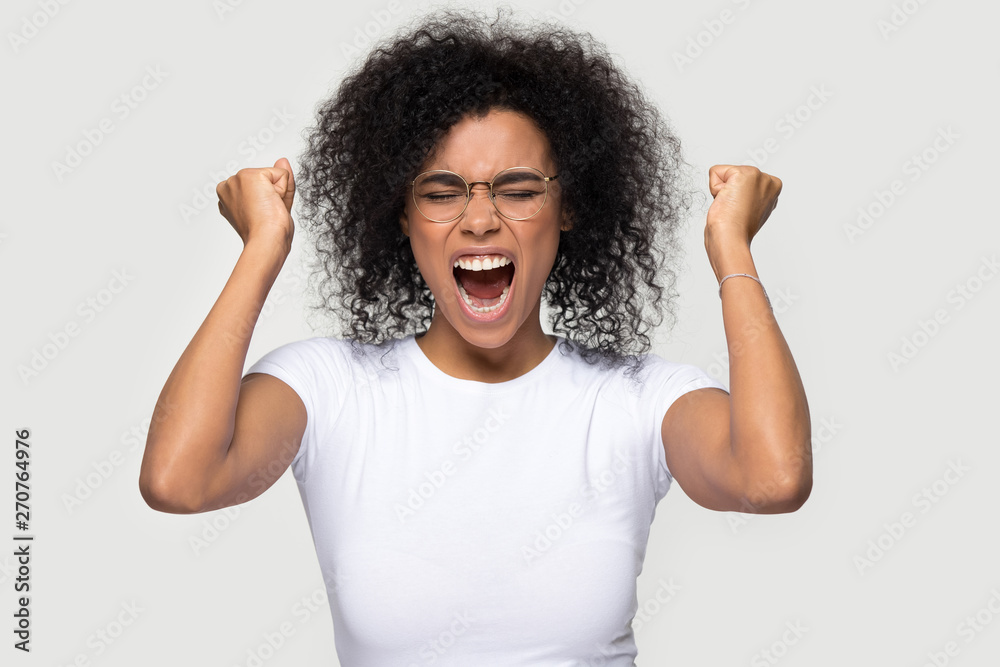 Happy cheerful excited african woman pose over grey background Happy cheerful excited african woman pose over grey background