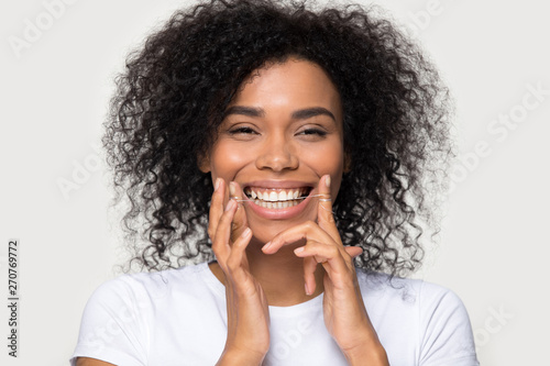 Slika na platnu Closeup portrait happy african woman cleaning teeth with dental floss