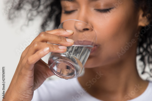 Canvas-taulu Close up african millennial female holding glass drinking water