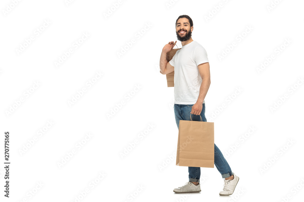 happy latin man holding shopping bags while standing isolated on white happy latin man holding shopping bags while standing isolated on white