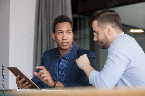 African American employee explain project to colleague at meeting