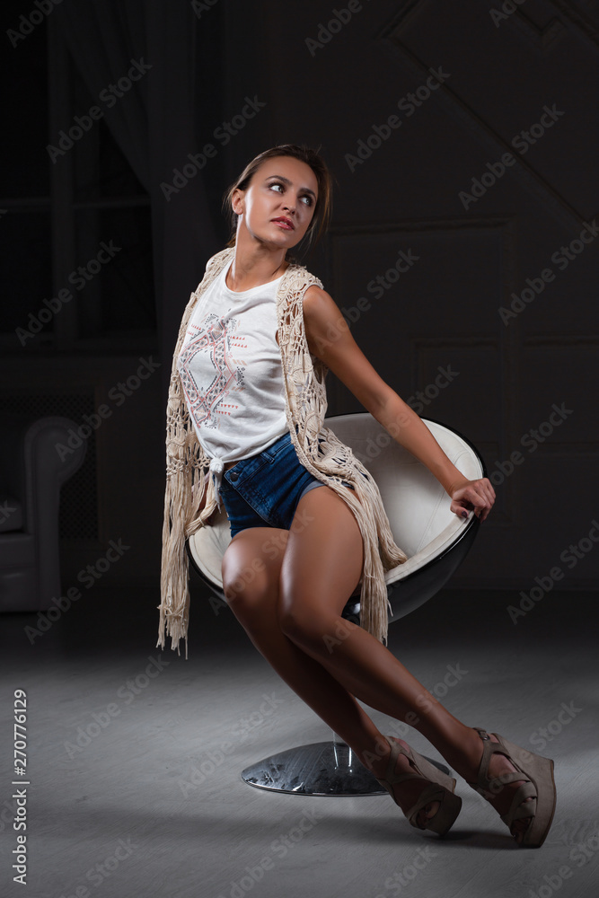 Naklejka premium Perfect lady posing sitting on a chair.