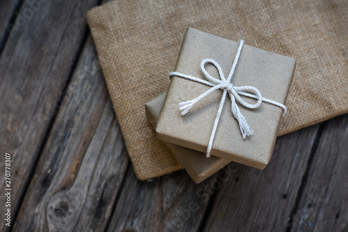 Brown paper gift box tie with rope on old wooden background