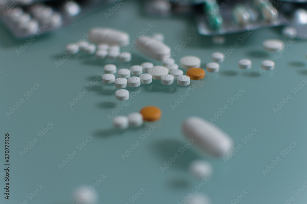 set of loose pills and complete tablets on green glass table set of loose pills and complete tablets on green glass table