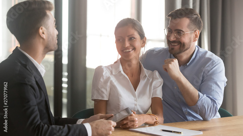 Foto Happy couple discuss home buying meeting with realtor