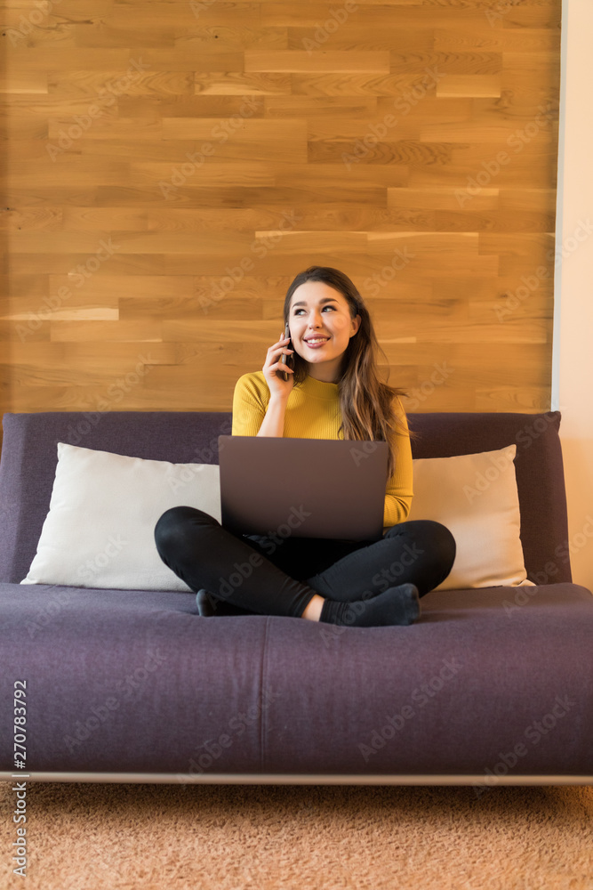 Young pretty woman working on a laptop sitting on bed at home. Young pretty woman working on a laptop sitting on bed at home.