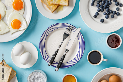 top view of table setting for breakfast on blue background