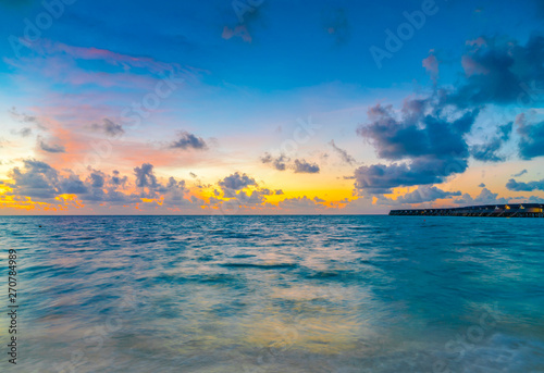 Beautiful sunset with sky over calm sea in tropical Maldives island .