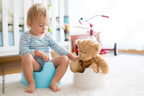 Bild auf Leinwand Cute toddler boy, potty training, playing with his teddy bear