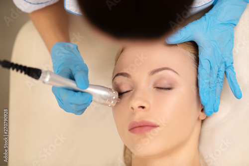 Top view of dermatologist doing under eye skin treatment