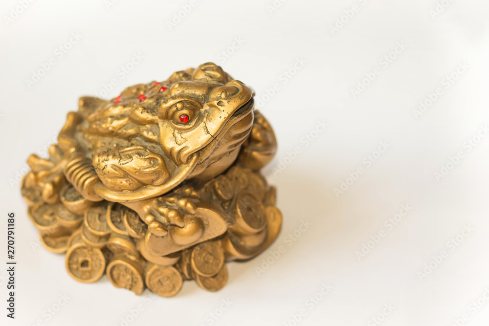 Cash mascot - Chan Chu - a gold frog figurine sitting on coins isolated on white background, in profile Cash mascot - Chan Chu - a gold frog figurine sitting on coins isolated on white background, in profile