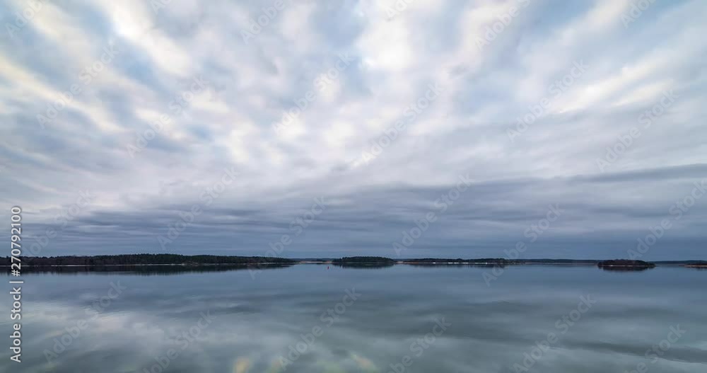 Timelaps of clouds moving over the calm sea with the clouds reflecting in the water Timelaps of clouds moving over the calm sea with the clouds reflecting in the water