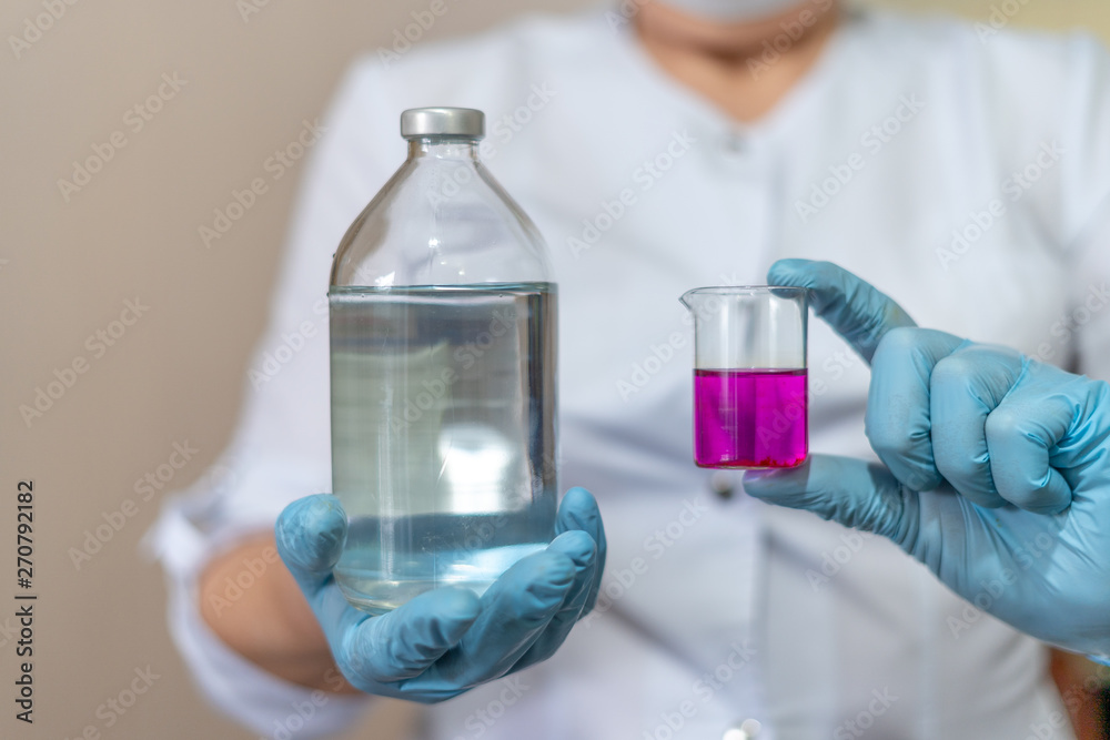 Doctor or scientist conducts experiments and presents vial liquid laboratory sample and contrasty potassium permanganate medical bottle. Pharmacy, science, research lab and healthcare concept. Doctor or scientist conducts experiments and presents vial liquid laboratory sample and contrasty potassium permanganate medical bottle. Pharmacy, science, research lab and healthcare concept.