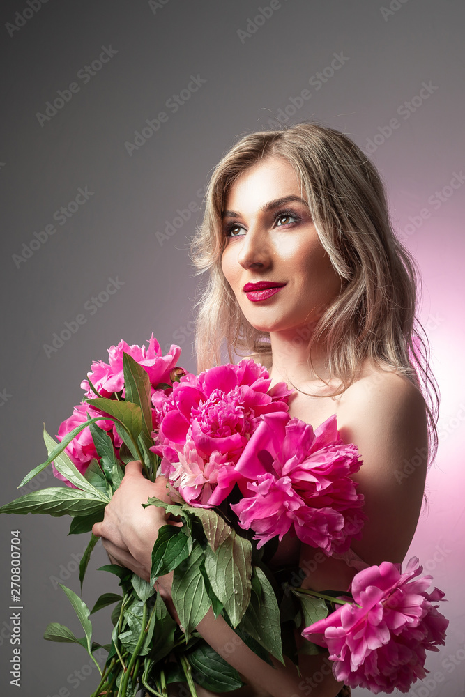 Close up ortrait of a beautiful young woman with a bouquet of fresh summer flowers