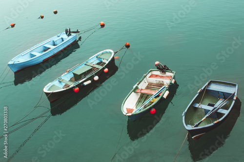four colorful boats in the turquoise sea © EGHStock