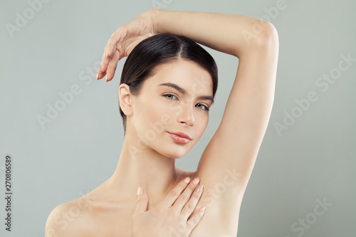 Young beautiful woman with healthy skin portrait holding hand up and showing armpits