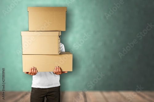 Man with cardboard boxes on brick background