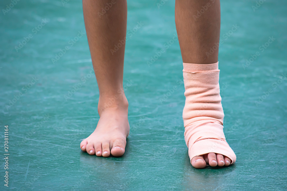The gauze bandages around the Ankle boy and leg swelling from inflammation On a green background. The gauze bandages around the Ankle boy and leg swelling from inflammation On a green background.