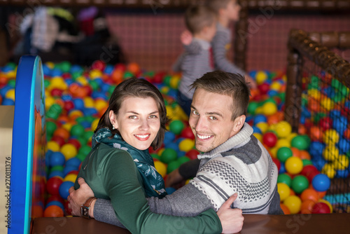 parents and kids playing in the pool with colorful balls photo