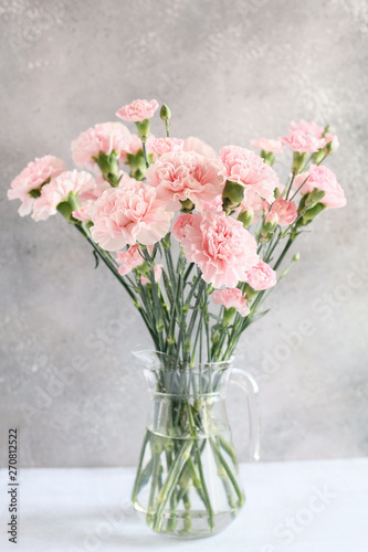 Fototapeta Naklejka Na Ścianę i Meble -  gentle pink carnation flowers in vase on grey background 