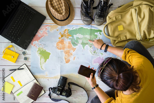 Travel planning concept with map. Overhead view of equipment for travelers. Travel concept background  Young woman pointing to the map China. concept on vacation trip with map.