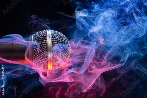 microphone enveloped in multicolored smoke on black gìbackground