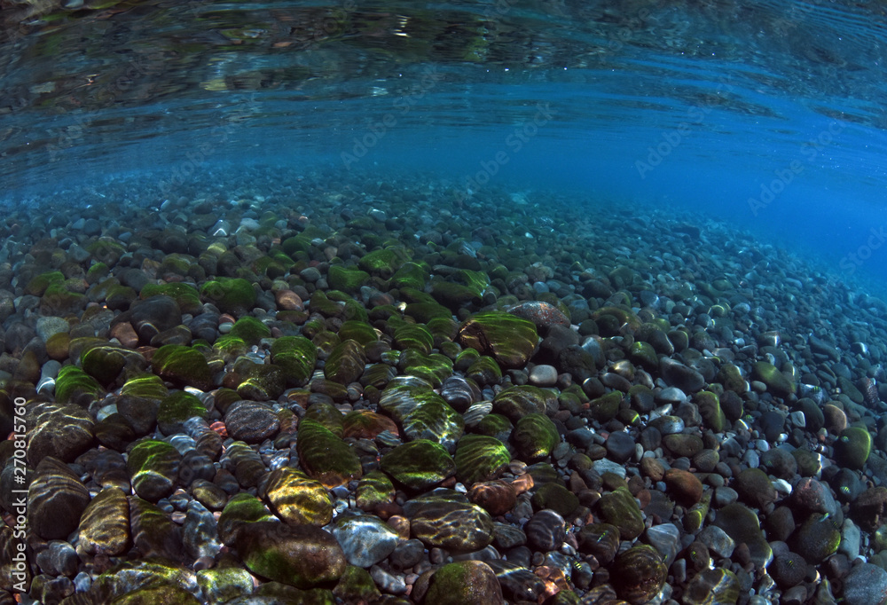 Underwater background. Clear blue ocean. Half water, split. Diving, snorkeling, swimming. Tulamben, Bali, Indonesia.