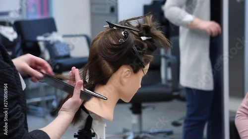 beginner hairdresser practices new skills on a mannequin head, simulates hair cutting with scissors, training at hairdressing workshop, learning new profession or refresher course