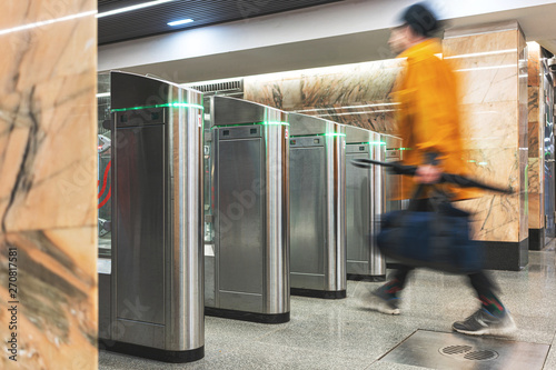 turnstile in the subway, at the station. Passenger control system. A man passes through the turnstile. photo