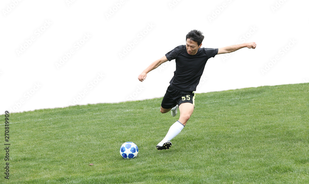 Asian soccer player kicking ball isolated on white