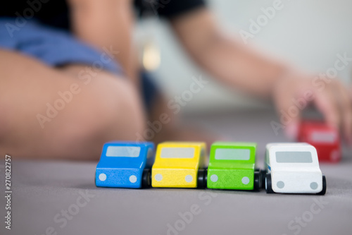 Colorful of wooden toy car with blur of kid background © Dontree
