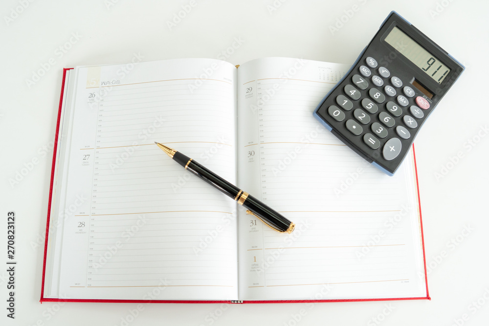Daily plan book spread out with a fountain pen and calculator on it. Daily plan book spread out with a fountain pen and calculator on it.
