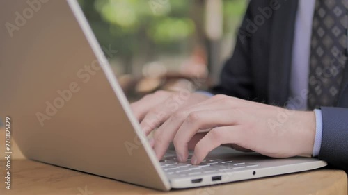 Hands of Businessman Typing on Laptop photo