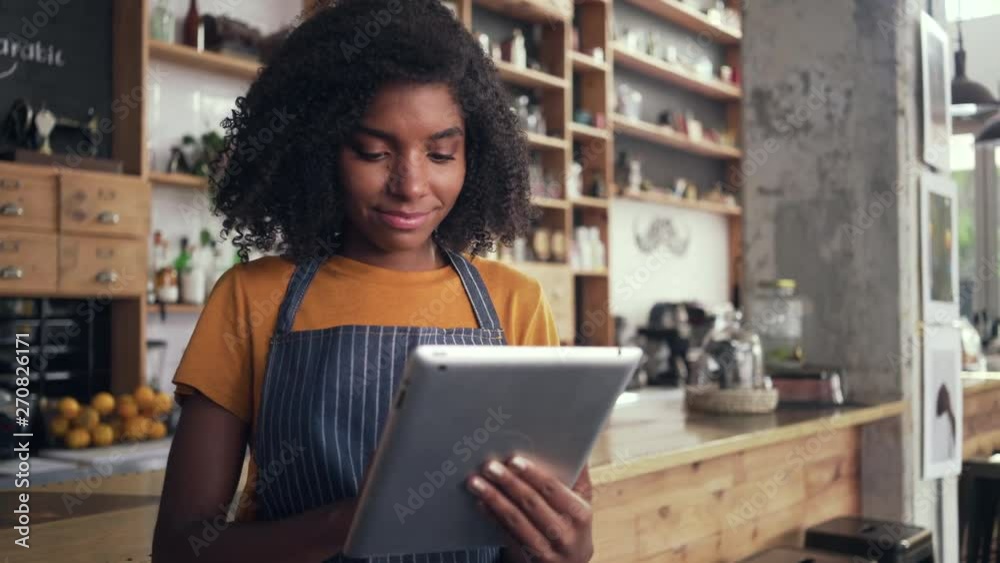 An african female cafe owner using digital tablet