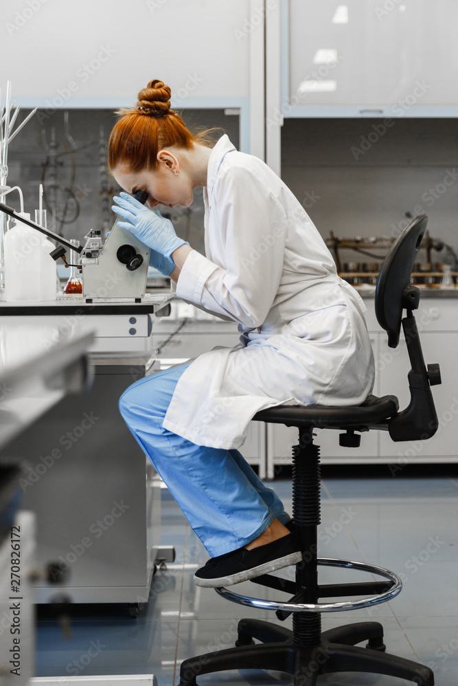 red-haired woman works in the medical laboratory red-haired woman works in the medical laboratory