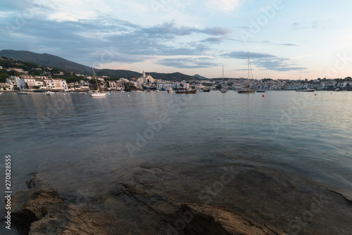 A morning view of Cadaqués. The Catalan village, under a cloudy sky with boats at foreground.