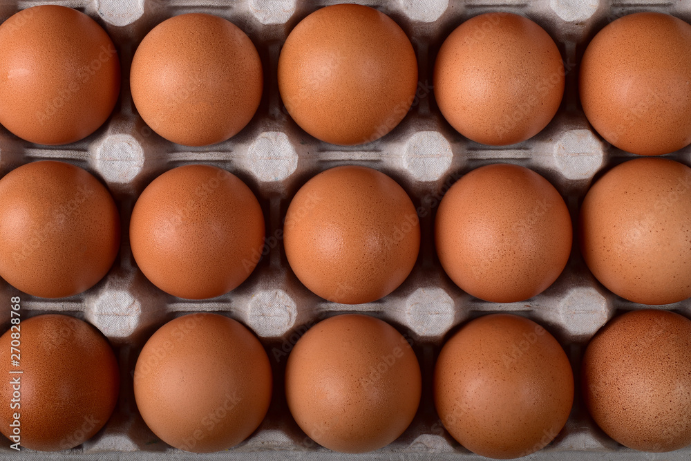 Three even rows of brown chicken eggs in the nests of the carton Three even rows of brown chicken eggs in the nests of the carton